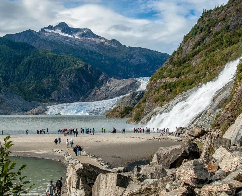 Visitors walk out to the Nugget Falls next to the Mendenhall Glacier